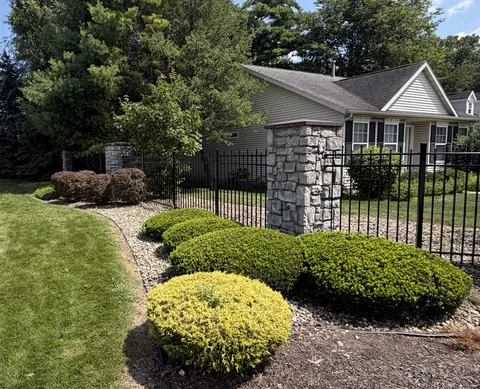 Dark metal fencing beside stone posts