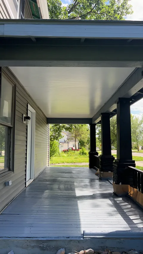 Long covered porch with dark posts