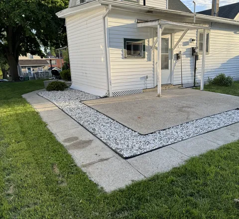 Outdoor concrete slab edged with decorative stone