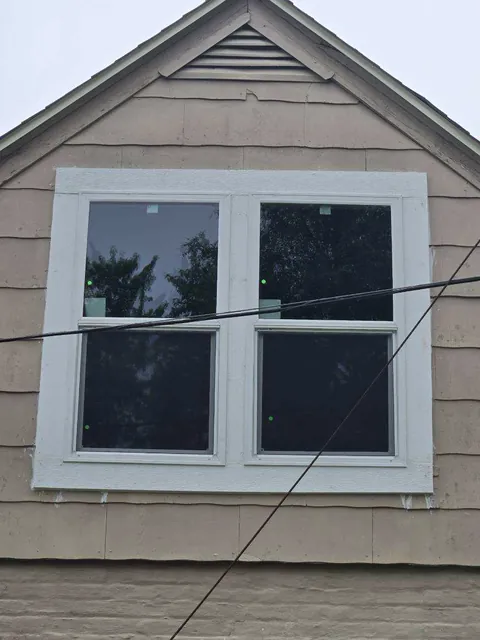 Pair of white framed windows beneath a gable