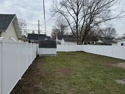 White fence enclosing a backyard