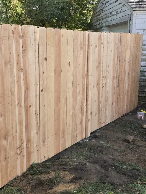 Wood privacy fence beside an outbuilding