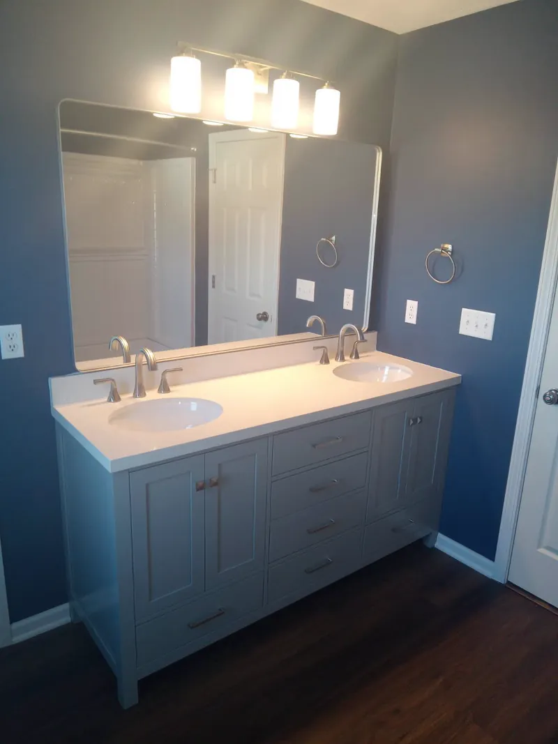 Double sink vanity with a wide mirror and blue bathroom walls