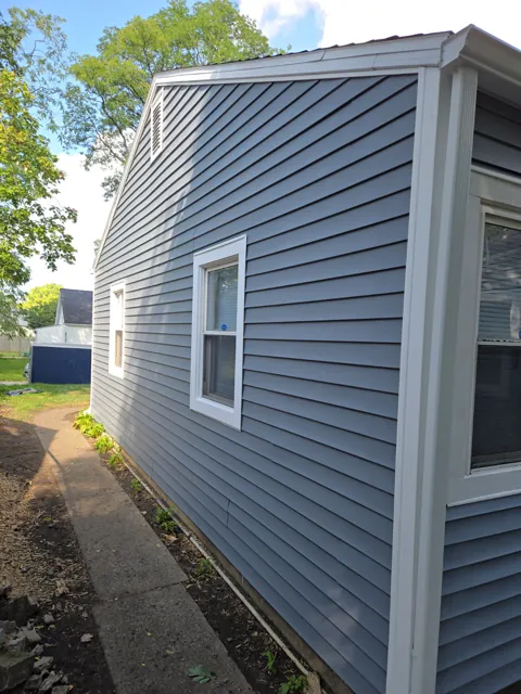 Gray siding around a white framed window