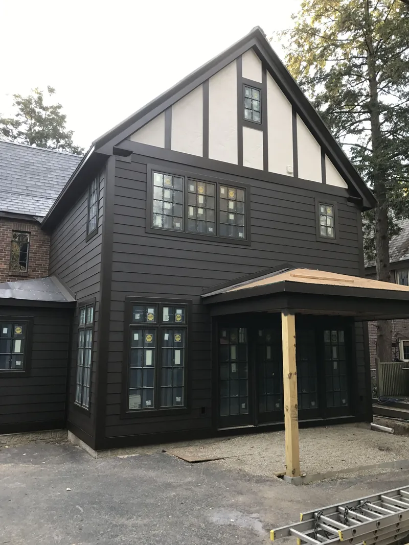 Later addition exterior with siding and windows, with porch details still in progress